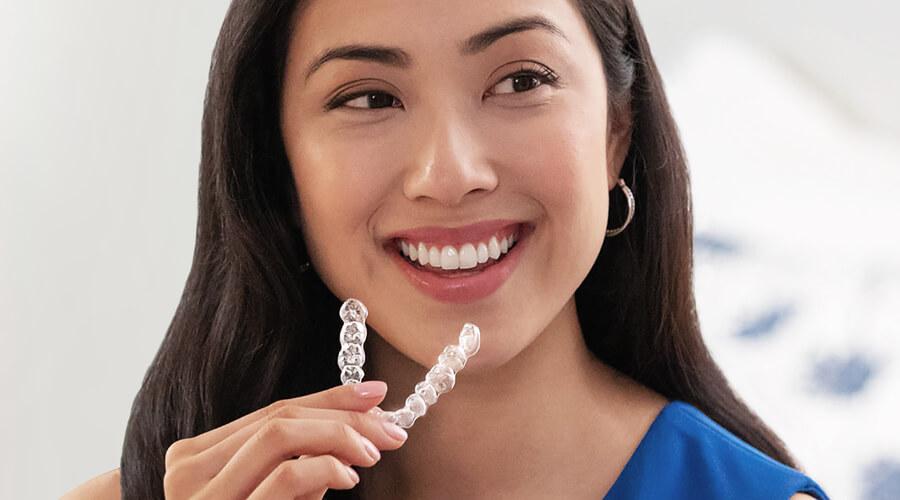 Woman showing off results of Invisalign® treatments from Ross Dental of New Berlin & Waukesha